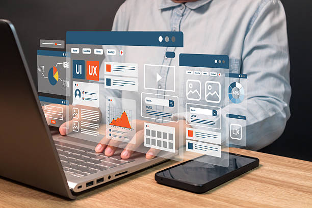 A web developer working on laptop to develop mobile phone and laptop app interface layout design. UX-UI development concept.